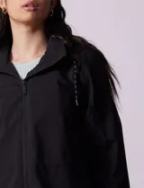 Gabardina impermeable color beige, marca Weatherproof, con cierre central, bolsillos delanteros con botones a presión, capucha desmontable y forro interno.