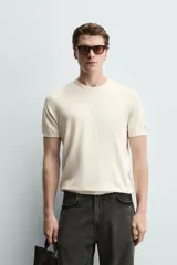 Camiseta de punto de corte regular, confeccionada en una mezcla de viscosa. Presenta cuello redondo y mangas cortas con acabados en rib.