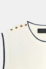 Jersey de punto azul marino sin mangas, con cuello redondo, ribetes en contraste y detalles de botones dorados en el hombro.