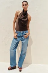 Top de cuello halter satinado en color naranja tostado, con espalda descubierta y cierre trasero de botones.