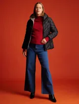 Campera puffer negra marca Michael Kors, con capucha no desmontable y cordón de ajuste. Tiene cierre metálico central, bolsillos verticales delanteros y avíos metálicos con logo. Incluye bolsa autoportante.