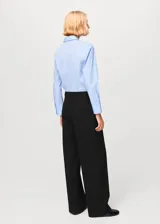 Camisa de popelina celeste, de silueta slim, manga larga y cuello camisero.