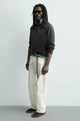 Sandalia tipo chinela de hombre, con suela plana color verde oscuro y tiras negras en el empeine.