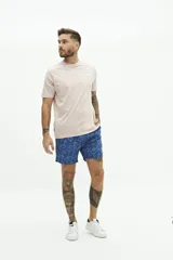 Short de baño con estampado floral en tonos azules, cintura elástica con cordón ajustable, bolsillos laterales y bolsillo trasero.