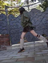 Botas altas de cuero marrón combinadas con gamuza blanca con estampado de vaca, forradas en cuero y con cierre de bronce.