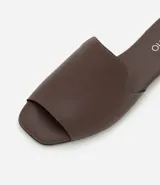 Sandalia plana Beira Rio de diseño minimalista, confeccionada en material sintético color marrón, con tira ancha sobre el empeine y taco bajo cuadrado.