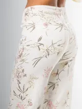 Pantalón wide leg de denim rígido con estampado floral chintz en tonos amarillo y rosa pastel sobre base blanca.