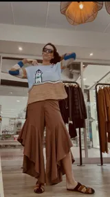 Pantalón de jean azul oscuro con diseño fluido y volados en las piernas.
