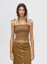 Top crop de tela fruncida con diseño ajustado al cuerpo, breteles finos con lazos ajustables y escote recto.