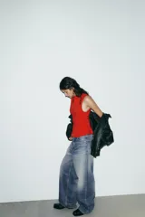 Top entallado rojo sin mangas, con cuello redondo y cierre frontal con cremallera oculta.