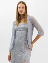 Vestido largo de encaje color beige, con escote recto decorado con pedrería y perlas, tirantes anchos y tajo lateral en la falda.