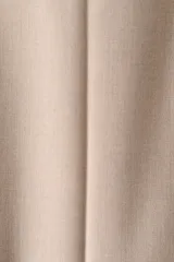 Pantalón de vestir de corte acampanado, color beige, con pretina, cierre frontal, bolsillos laterales y pliegues frontales.