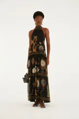 Vestido largo negro con cuello halter y diseño sin mangas, confeccionado en tejido liviano con estampado multicolor inspirado en elementos barrocos y tropicales.