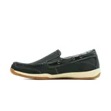 Mocasín de cuero negro estilo náutico, con costuras pespunteadas visibles, cordón decorativo lateral que pasa por ojalillos metálicos, suela de goma blanca y base caramelo con estriado antideslizante.