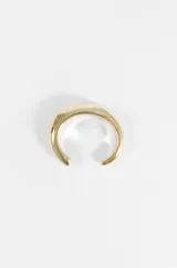 Pulsera tipo cuff de diseño minimalista y forma redondeada con acabado brillante en tono dorado.