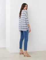 Buzo de tejido calado con diseño de rayas horizontales en tonos gris y blanco, cuello redondo y mangas tres cuartos. Incluye musculosa interna básica a tono.