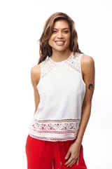 Blusa blanca sin mangas con detalles de encaje en el ruedo y los hombros.