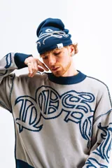 Sweater tejido reversible con cuello alto, puños y ruedo acanalados. Un lado es azul marino con diseño de letras en blanco y el otro lado es gris con diseño de letras en azul marino. Corte BoxyFit/RegularFit.