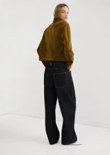 Jeans de mezclilla de corte holgado y tiro medio, en color azul oscuro, con diseño clásico de cinco bolsillos y costuras visibles en contraste.
