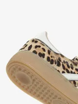 Championes Adidas modelo Handball Spezial con estampado animal print de leopardo. Presentan las icónicas tres tiras laterales en color blanco, cordones negros y una suela de goma color caramelo.