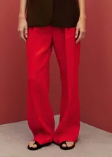Pantalon de vestir de corte recto y tiro medio, confeccionado en lino con forro de algodón. Presenta cierre frontal oculto con botón, gancho y cremallera, además de bolsillos laterales.
