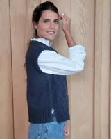 Chaleco de punto gris oscuro con diseño de trenzas y rombos en relieve, cuello redondo y terminaciones acanaladas.