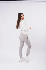 Pantalón de jogging color gris oscuro con efecto lavado, confeccionado en frizza de algodón. Presenta un diseño relajado con bolsillos laterales y un detalle bordado de alas en la parte frontal.