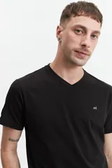 Remera verde con escote en V y logo bordado en el pecho.