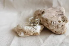 Anillo ancho plateado con diseño de calados irregulares.