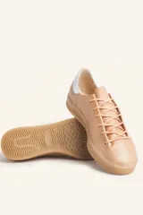 Zapatilla de cuero vacuno color azul marino, con cordones azules y suela de caucho color caramelo.