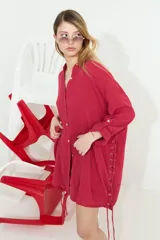 Camisa de algodón blanca, de manga larga y corte oversize, con diseño abierto en los laterales ajustable mediante cordón y ojalillos.