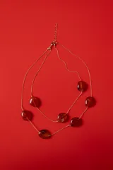 Collar doble de cadena dorada fina con cuentas marmoladas en tonos ámbar de formas orgánicas.