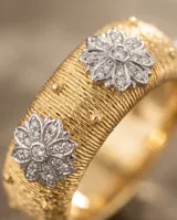 Anillo de bronce con baño de oro, diseño texturizado estilo malla y apliques florales incrustados con circonias brillantes.