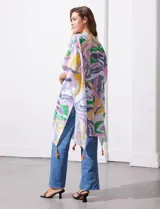 Kimono de manga amplia japonesa con estampado abstracto multicolor sobre fondo blanco. Presenta terminaciones con borlas en el ruedo.
