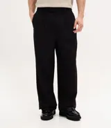 Pantalón de corte wide leg con diseño de sastrería, confeccionado en tejido estructurado con frisos frontales, bolsillos laterales y cierre invisible.