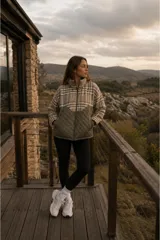 Campera de diseño combinado con cuello alto y cierre frontal. La parte superior presenta un estampado a cuadros en tonos beige y marrón, mientras que la parte inferior es de color verde oliva con un diseño acolchado en forma de rombos.