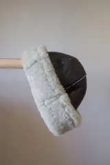 Gorro de cuero marrón con borde de corderito blanco.