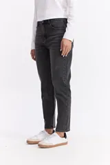 Jean estilo mom de tiro medio y corte recto con leve holgura, en color gris oscuro con efecto lavado. Cuenta con cierre frontal y bolsillos laterales y traseros.
