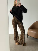 Pantalón tipo oxford de tiro alto con estampado animal print de leopardo, corte ajustado en la parte superior y acampanado en el ruedo.