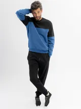 Pantalón de jogging negro de felpa, con cintura elástica y cordón ajustable. Presenta puños elásticos en los tobillos.