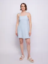 Vestido corto verde lima con textura arrugada, tirantes finos y corte recto.