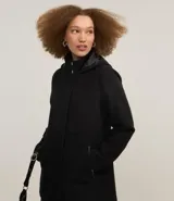 Saco largo de polivelour color negro, con cuello alto, capucha y cierre frontal de cremallera y botones. Presenta bolsillos laterales con cierre y forro interno.