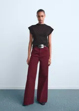 Jeans wide leg tiro alto color bordó, con cinco bolsillos, trabillas y cierre delantero de cremallera y botón.