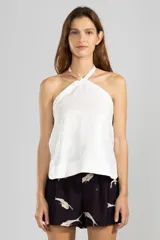Top halter blanco de lino italiano con hilo metalizado y escote con cordón ajustable.