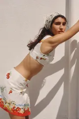 Minifalda cruzada de algodón con estampado de tomates y flores, corte evasé y diseño asimétrico.