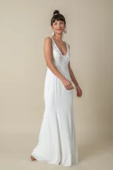 Vestido largo blanco de jersey, corte princesa con escote en V y bordado de perlas, canutillos y piedras.