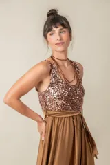 Vestido largo rojo con cuerpo de lentejuelas y falda de satén con caída fluida. Presenta escote redondo, sin mangas y un lazo en la cintura.