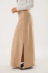 Falda larga color beige confeccionada en tela suave con acabado tipo piel de durazno y cierre invisible lateral.