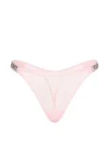 Tanga de encaje color rosado con tirantes brillantes y detalle de pedrería formando el logotipo en los laterales, de tiro bajo.