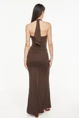 Vestido largo color verde oscuro, de corte entallado y silueta fluida, con escote halter pronunciado y detalle fruncido en la cintura.